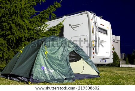 Mikolajki, Poland, August 03, 2014: Tent and vehicle trailer in the camping at night in Mikolajki, Poland.