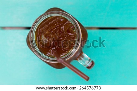 iced black coffee in glass on wood tray