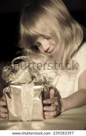 beautiful blond girl with gift in hands