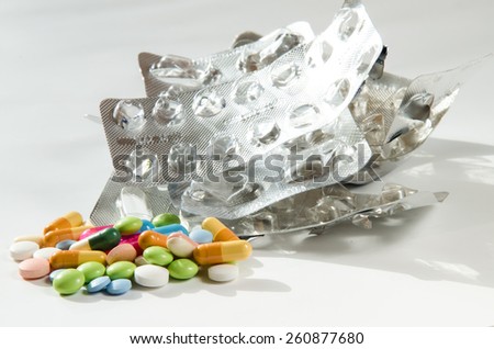 group of pills and silver empty pills blister isolated