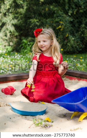 adorable blond girl playing in sandpit