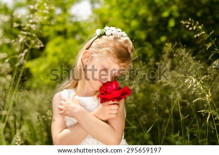 beautiful blond little girl with flower headband holding red rose