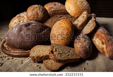 Fresh bread and wheat on the wooden table.