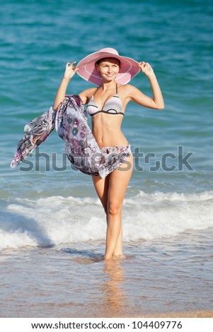 Attractive girl in hat at the sea. Young woman posing on seashore