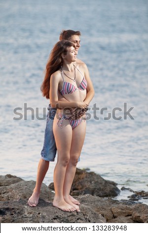Attractive couple at the sea. Young heterosexual couple flirting at the sea in evening time