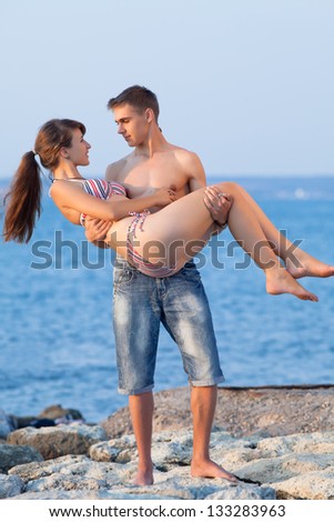Attractive couple at the sea. Attractive guy and girl are playing at the sea in evening time