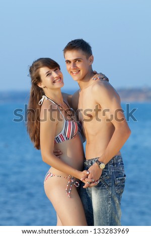 Attractive couple at the sea. Young heterosexual couple flirting at the sea in evening time