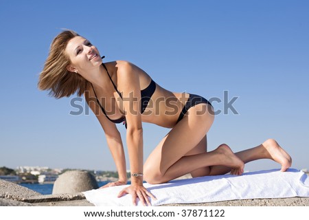 Attractive young woman in black swimsuit on all fours