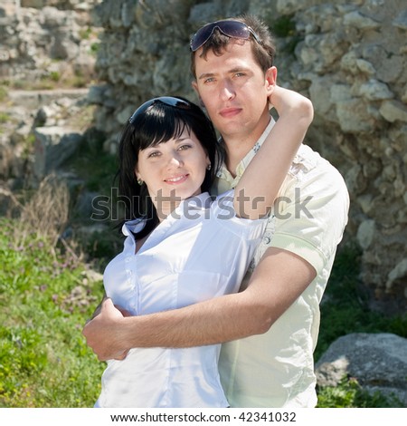 Attractive young man and woman are playing outdoors and are looking at camera