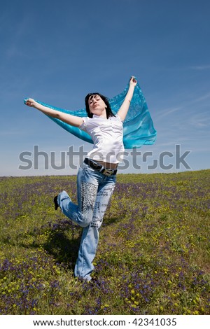Young woman in jeans is running through field
