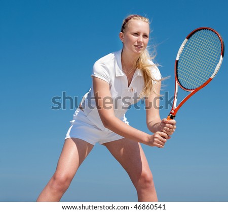 Young blond  tennis-player in white sportwear outdoors
