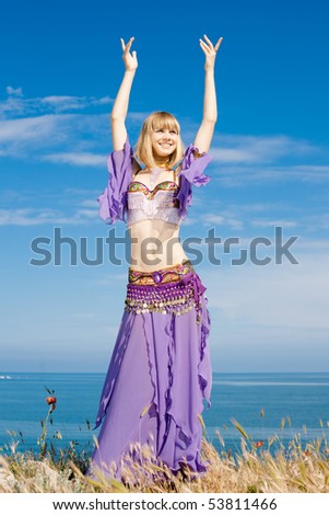 Slim girl in costume for oriental dance on seashore