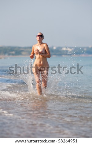 stock photo Naked woman running along the beach