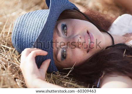 Portrait of brunette in hat. Young woman in costume of cowboy looks at camera