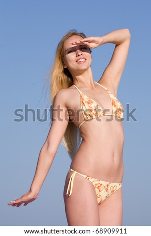 Blonde in bikini at the sea. Attractive young woman in bikini looking at camera