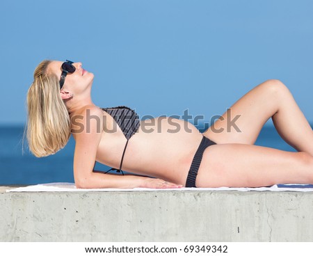 Pregnant woman in swimwear outdoors. Attractive expectant mother in bikini lies on back