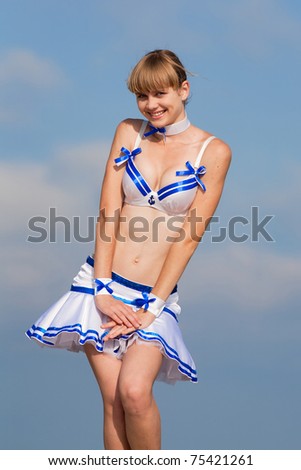 Blonde in dancing suit outdoors. Young woman holds her skirt blown by wind