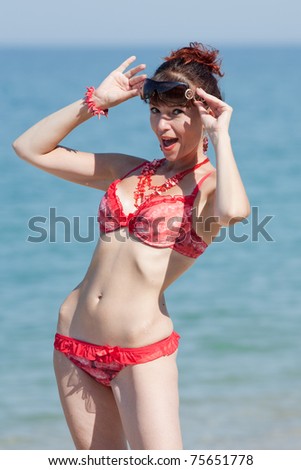 Middle aged woman looking from under sunglasses. Surprised woman on the beach
