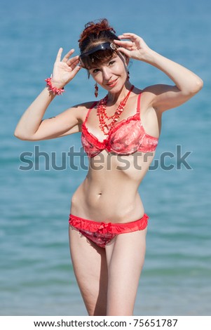 Middle aged woman looking at camera from under sunglasses. Woman at the sea