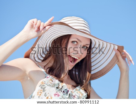 stock photo Laughing girl hides her naked breast behind hat looking at