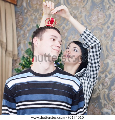 Happy young couple at Christmas. Happy young woman and man in domestic room on Christmas day.