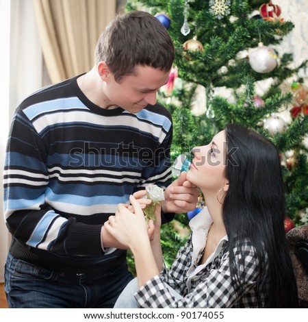 Happy young couple at Christmas. Happy young woman and man in domestic room on Christmas day.