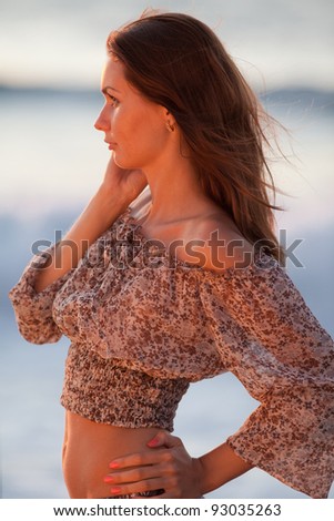 Lady at the sea. Attractive young woman in shorts and blouse on background of sea. Girl looking away