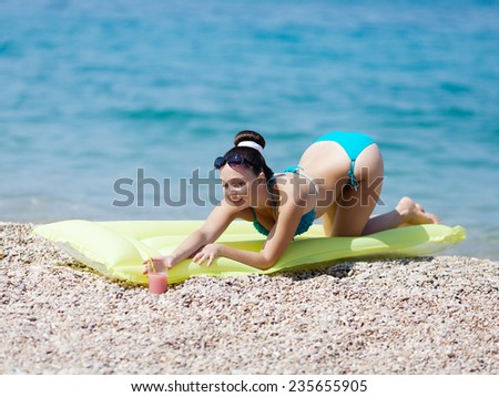 Girl at the sea. Attractive young woman standing on all fours on pebble beach
