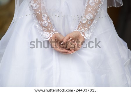 Wedding hands. Bride holds her hands behind back