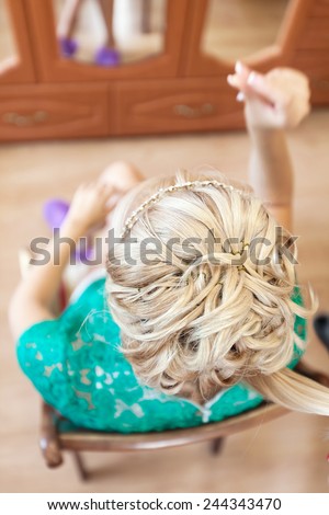 Hair styling. Top view of blonde woman during hair styling