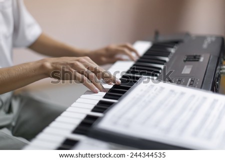 Hands of musician. Pianist playing on a synthesizer indoor. Shoot with shallow depth of field