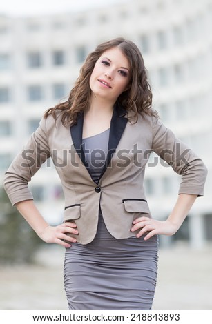 Attractive business woman in town. Urban young woman posing with hands on her waist