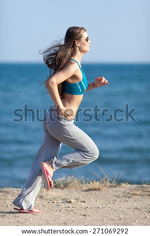 Jogging. Slim girl in flip-flop runs along the seashore