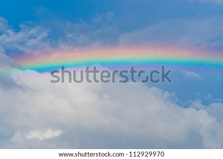 Rainbow in the cloudy sky after the rain