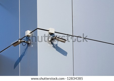 A security cameras on the side of an office building.