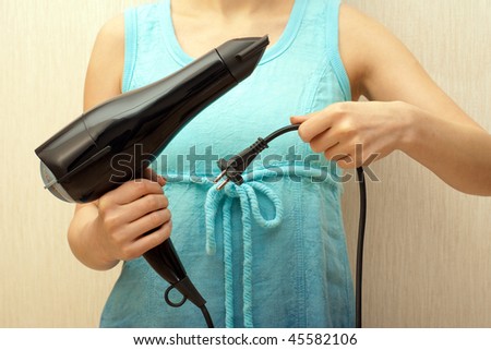 Woman holding professional black hairdryer in her hands
