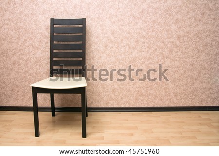 Modern wooden chair against a wall
