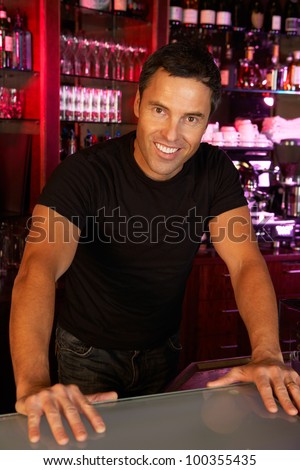 Portrait Of Barman Standing Behind Bar