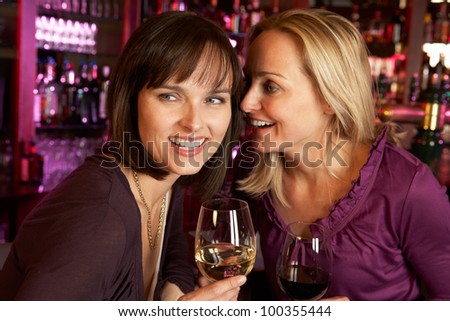 Two Women Enjoying Drink Together In Bar