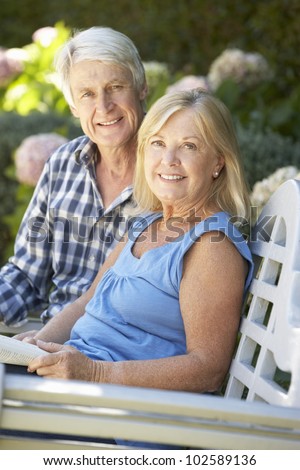 Senior couple reading in garden