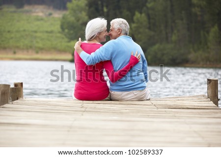 Romantic senior couple sitting on a jetty