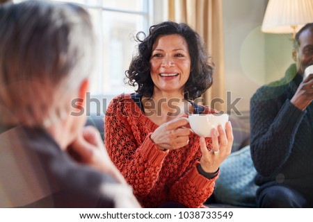 Middle Aged Woman Meeting Friends Around Table In Coffee Shop