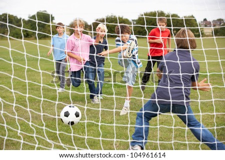 Boys playing soccer in park