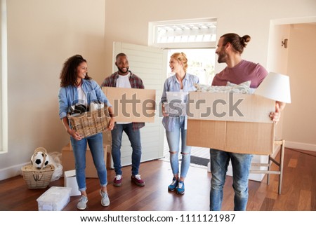 Friends Help Couple To Carry Boxes Into New Home On Moving Day