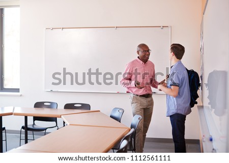 High School Tutor Talking With Male Student After Class