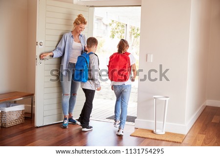 Mother Getting Children Ready To Leave House For School