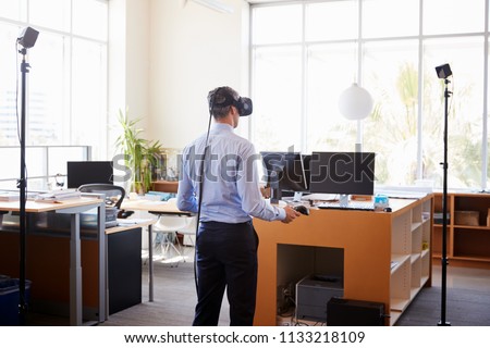 Businessman using VR technology in an office, back view