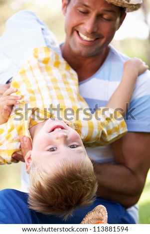 Father And Son Playing In Summer Garden