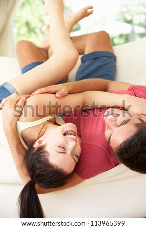 Couple Lying Upside Down On Sofa