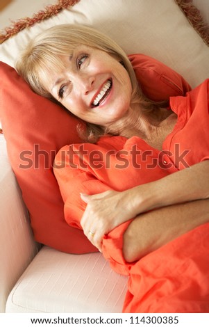 Senior Woman Relaxing On Sofa At Home